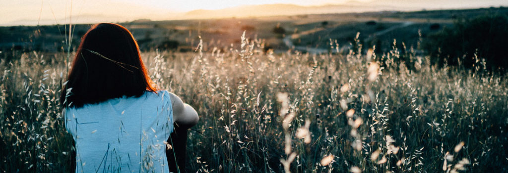 girl in field wondering how to support someone in rehab