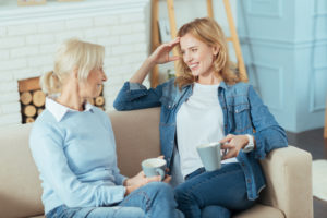 young woman in mindfulness exercises looking interested while talking to her clever grandmother