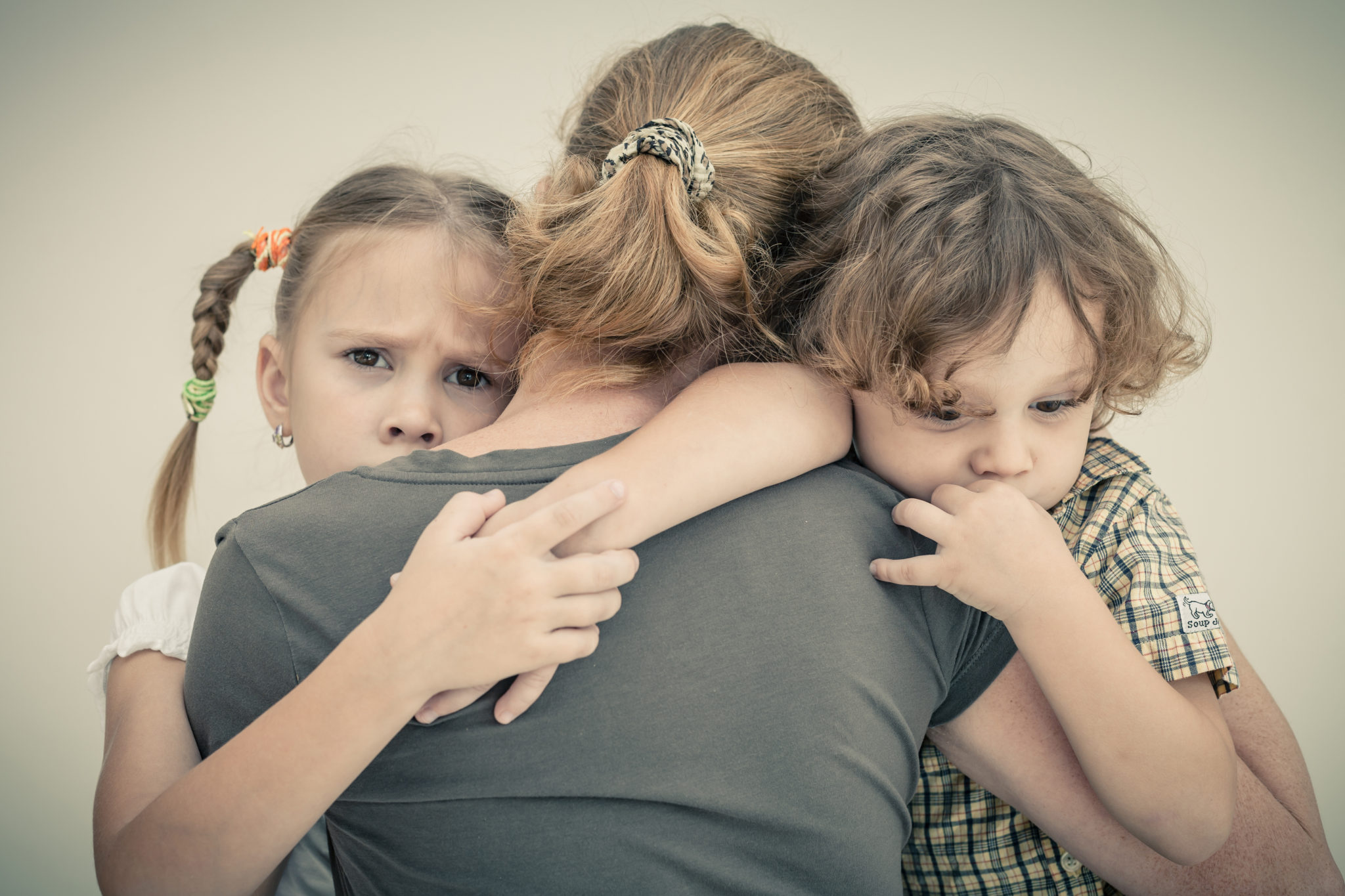 women in recovery showing two children hugging mother fearful of loosing her children