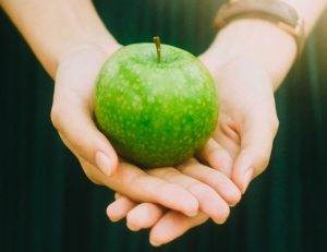 apple in hand showing mental health and nutrition related in women