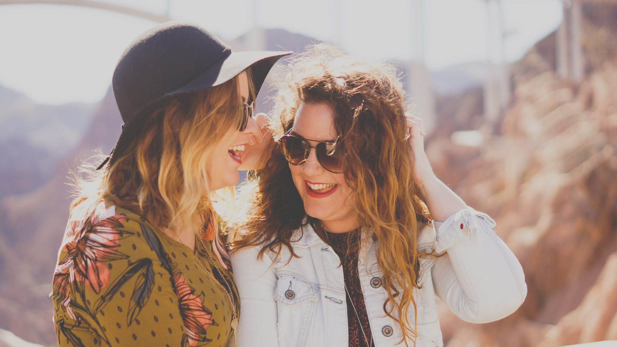 two smiling women with hats outside after residential substance abuse treatment