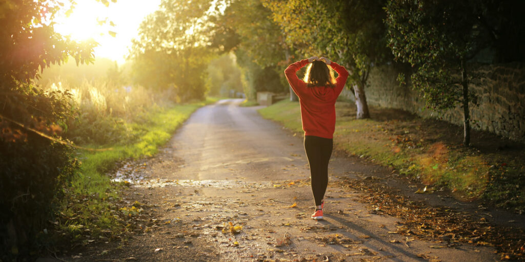 Woman walking on pathway during daytime.