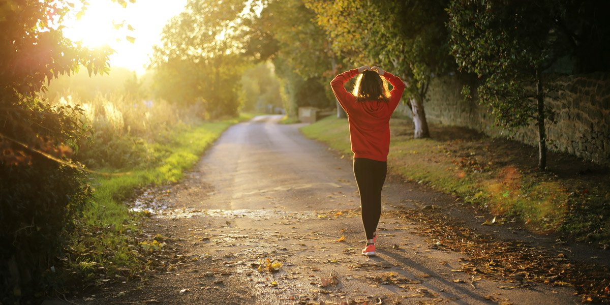 Woman walking on pathway during daytime.