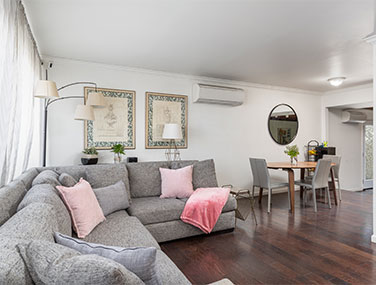 a gray couch in a comfortable, sunny living room