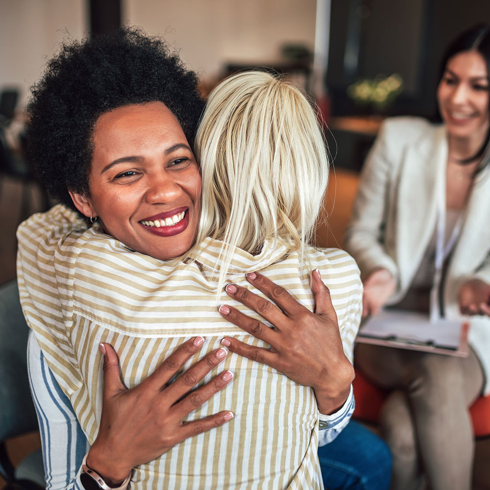 2 women hugging and smiling