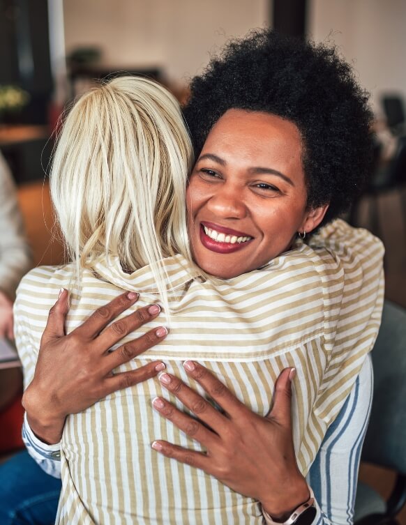 2 women hugging and smiling
