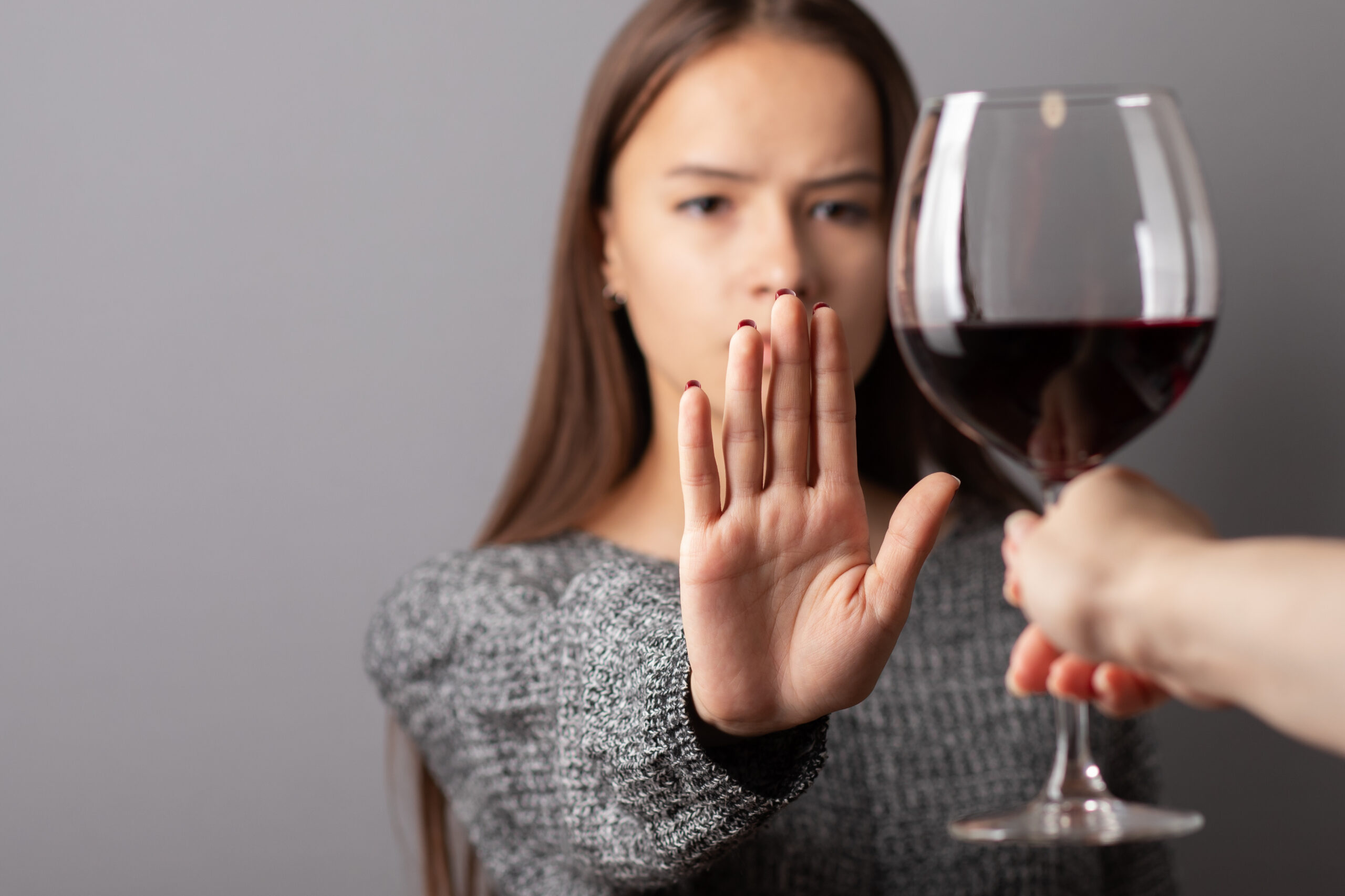 Hand refusing glass of alcohol.