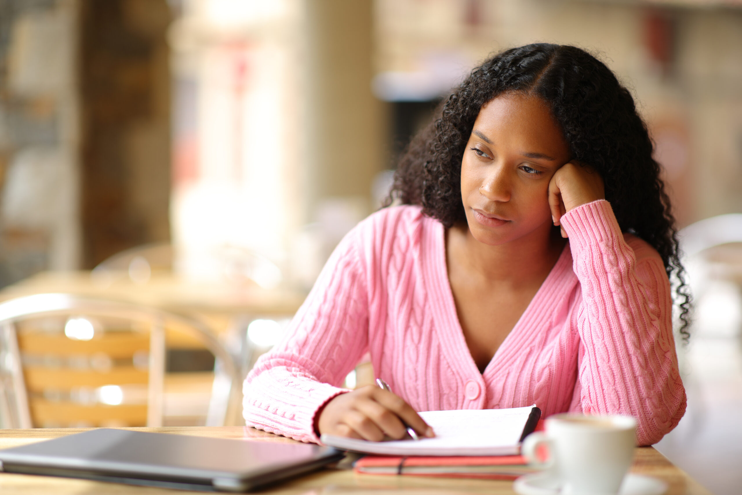 Woman appearing distracted while writing.