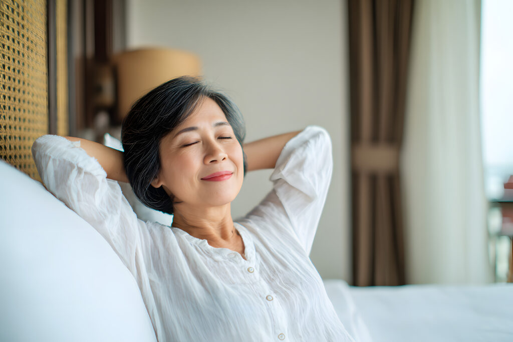 Woman relaxing with eyes closed and smiling.