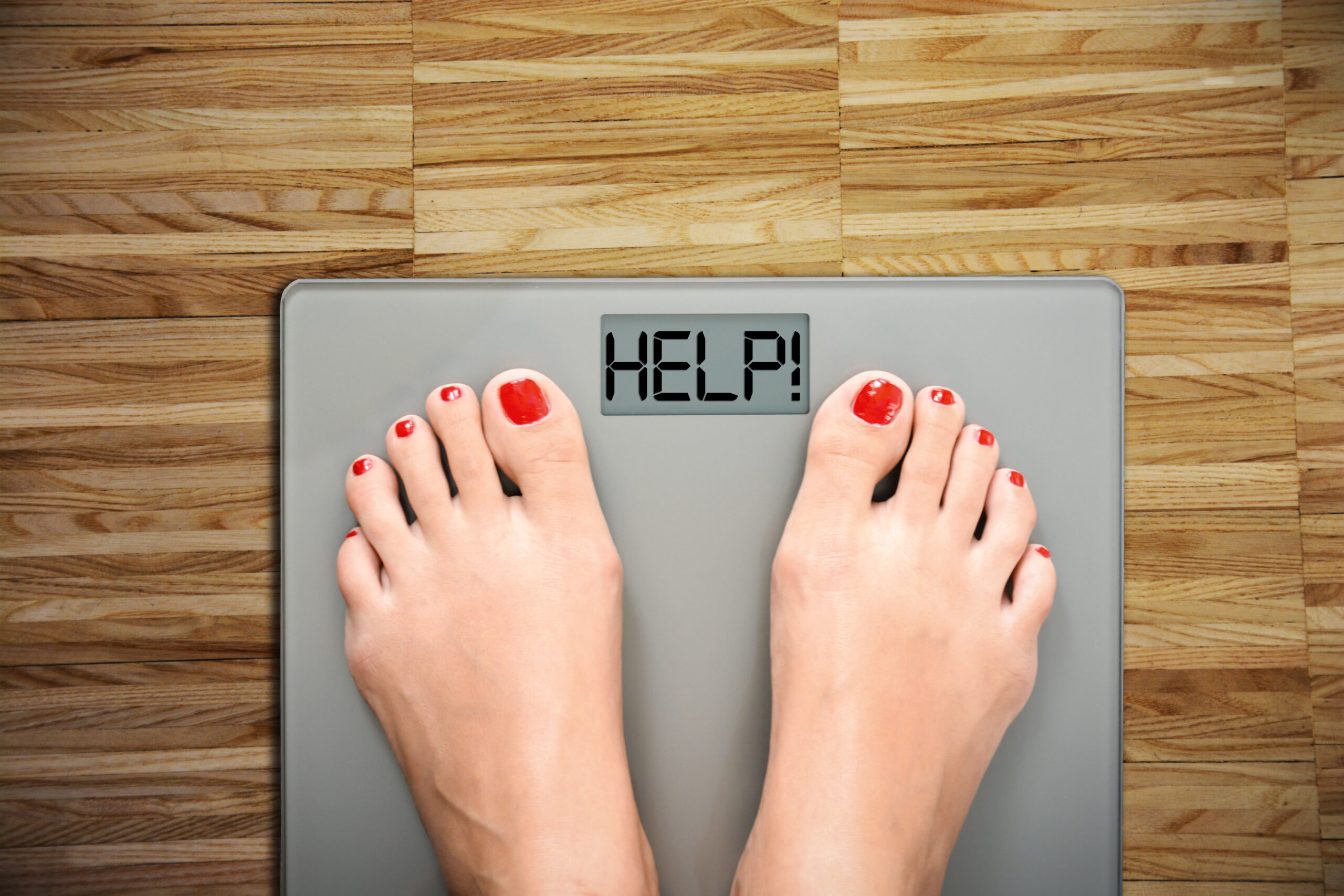 Feet on scale displaying the word “help.”