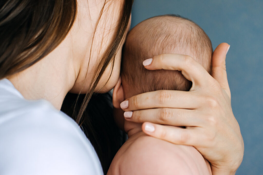 Mother holding newborn baby close.