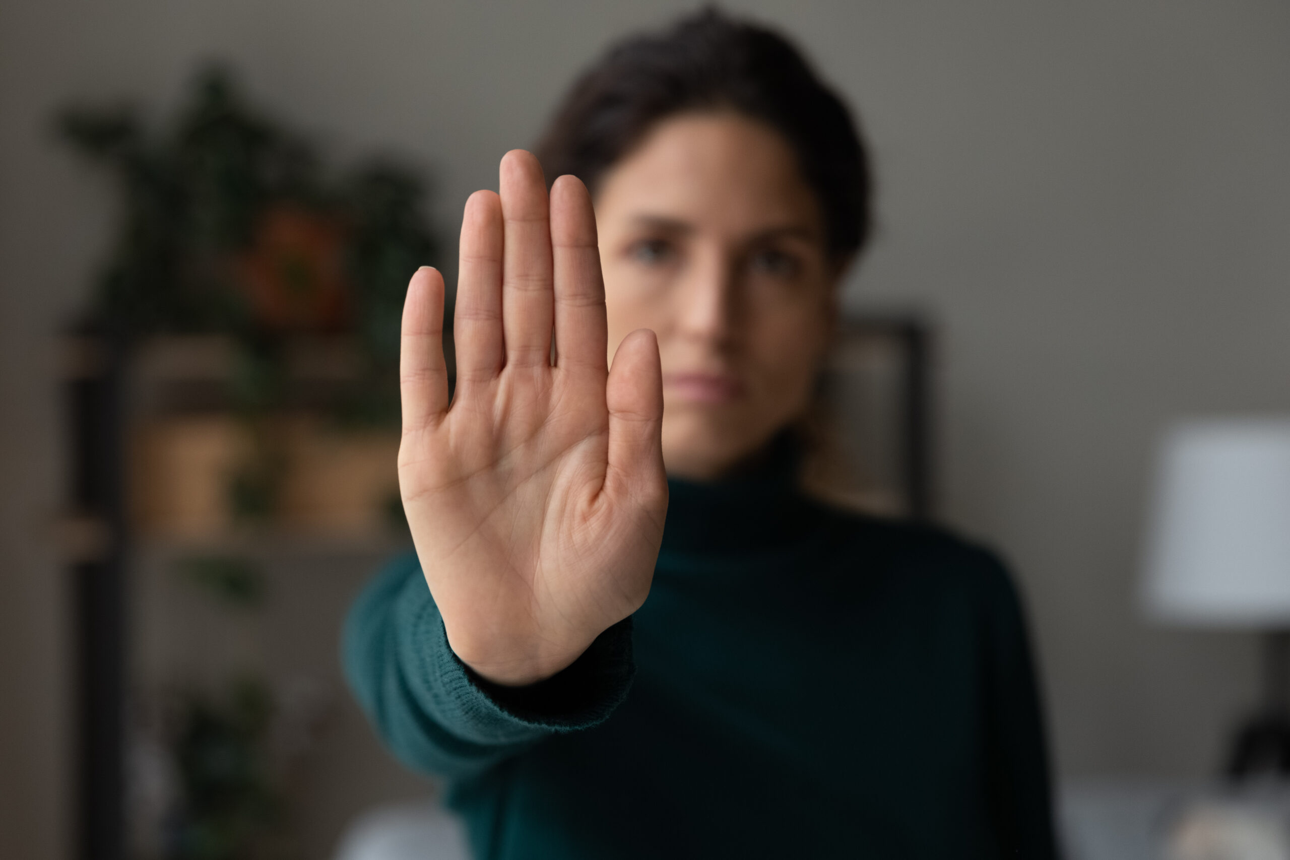 Woman holding her hand up to set a boundary during recovery.
