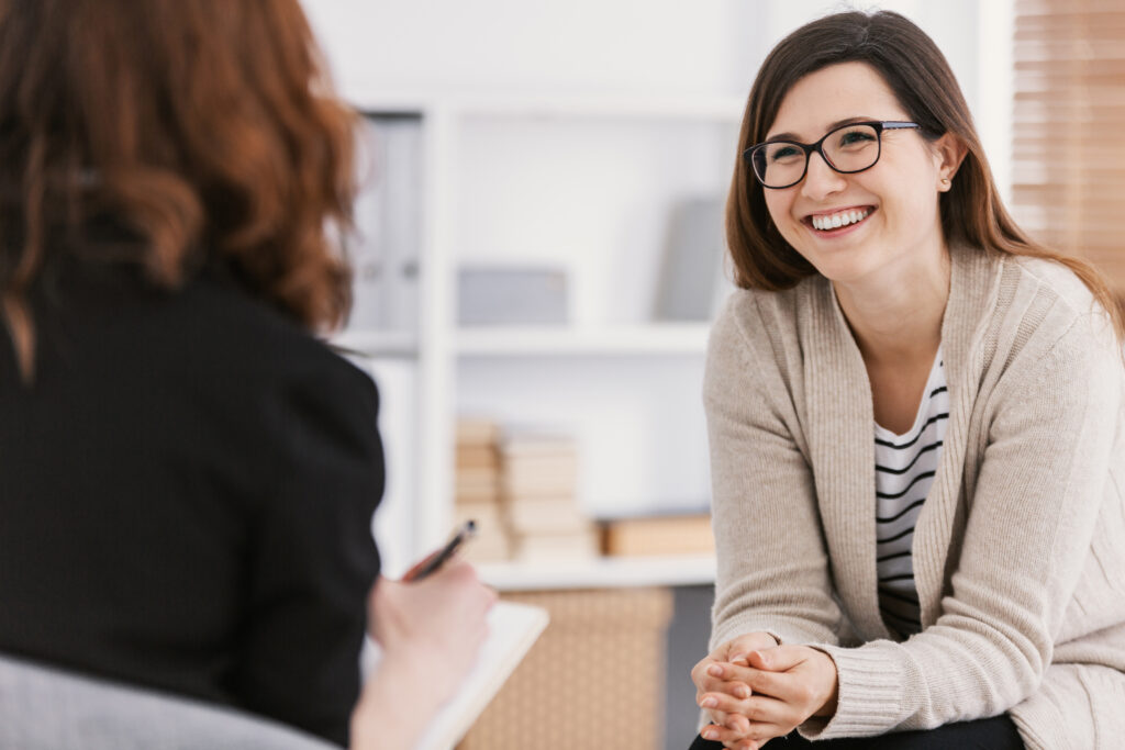 Woman smiling during therapy session for eating disorder recovery.