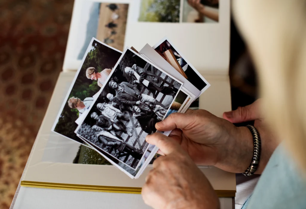 Hands sorting through old family photographs on a table