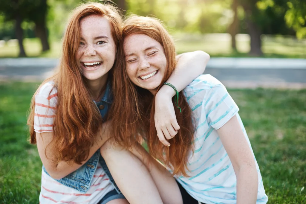 Two young sisters sitting side by side