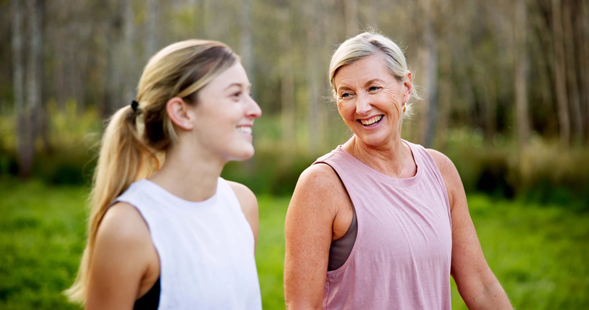 Mother and daughter walking together outdoors seen from behind