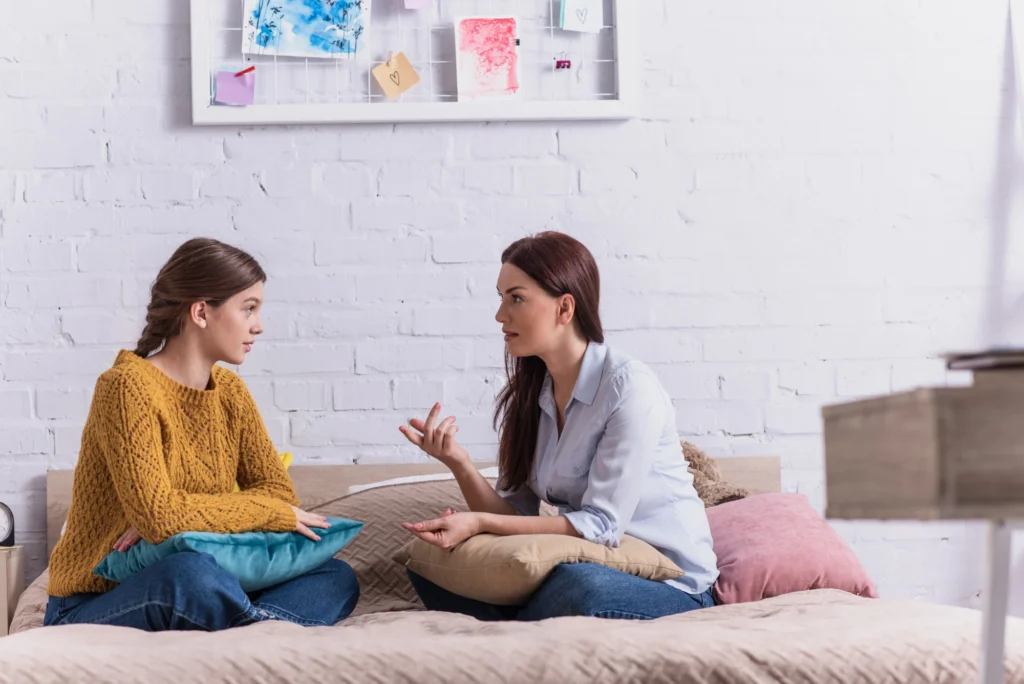 Mother and daughter sitting together on a couch having a conversation