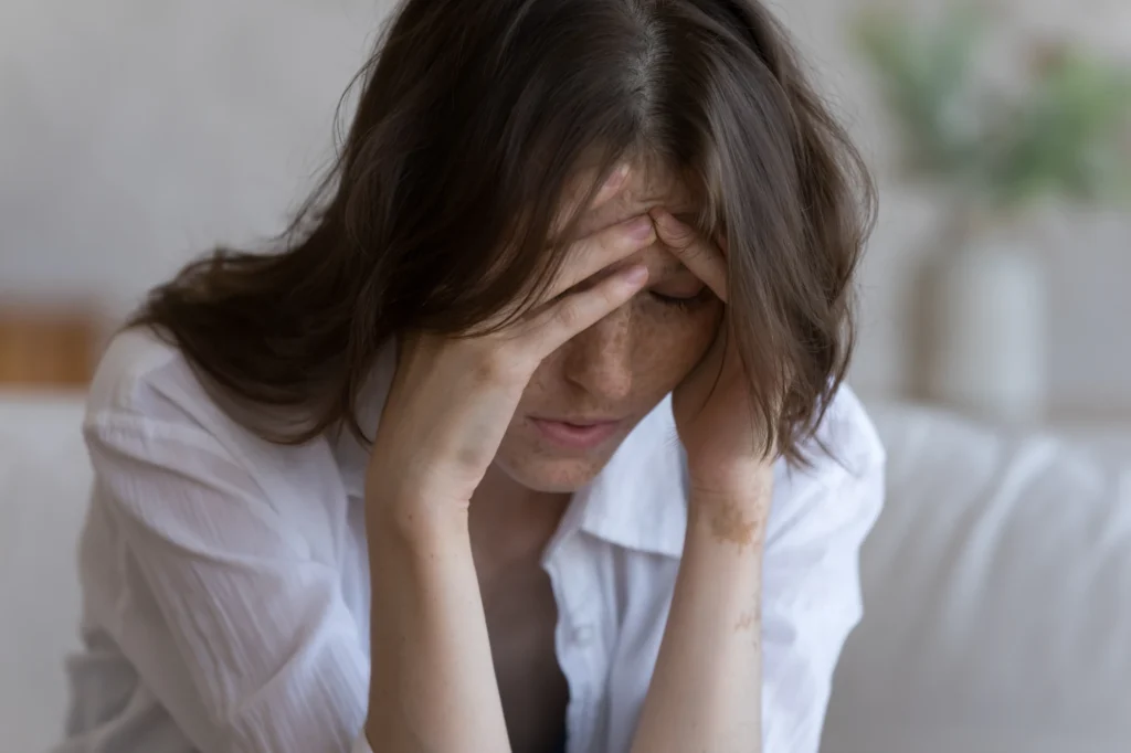 Woman sitting alone looking thoughtful in a quiet room at home