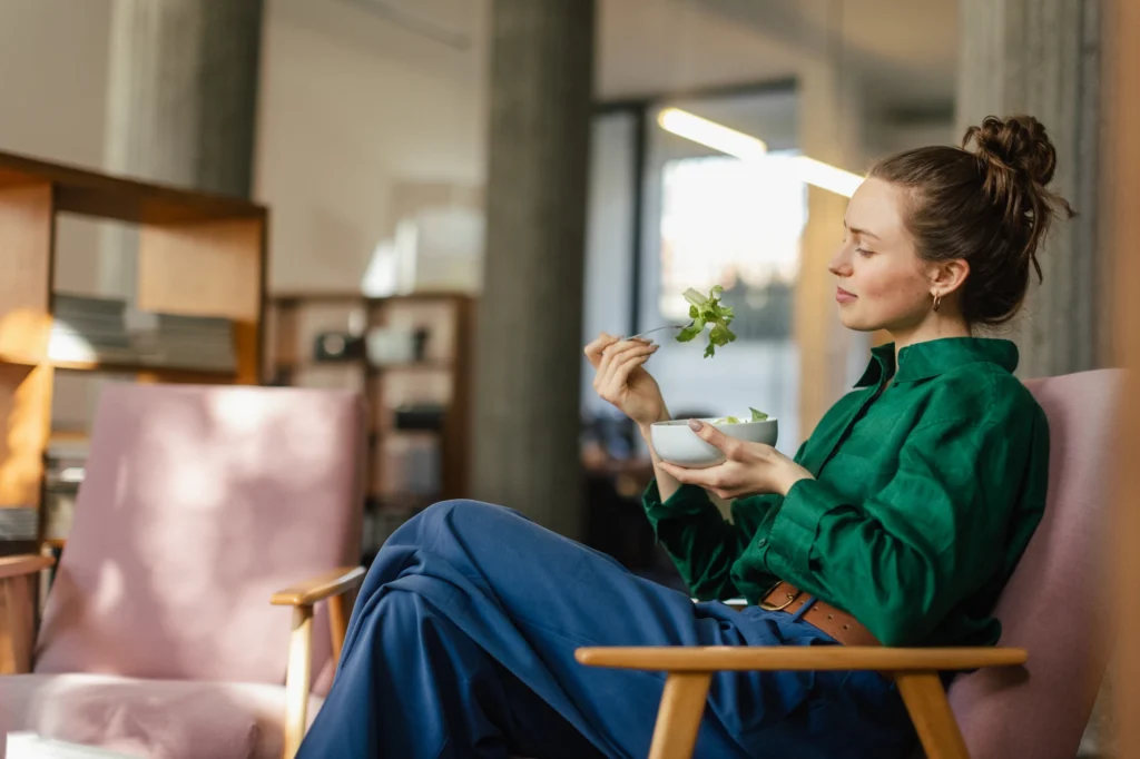 Woman resting a hand on her stomach after finishing a meal